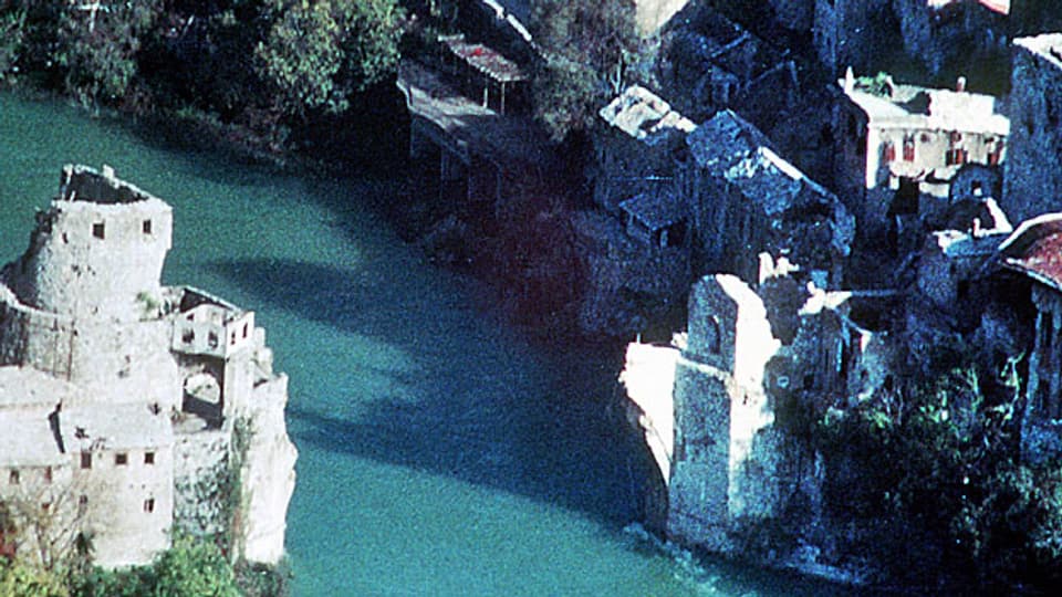 Ruine der Brücke über den Fluss Neretva in Mostar, aufgenommen im November 1993. Die Steinbrücke galt als Symbol für Mostars ethnische Vielfalt; sie wurde im Bosnienkrieg zerstört.