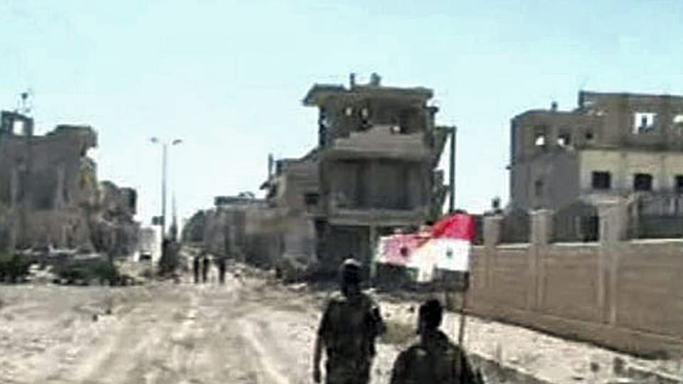 Assads Truppen tragen zum Zeichen ihres Sieges über die Rebellen eine syrische Fahne durch Qusair.
