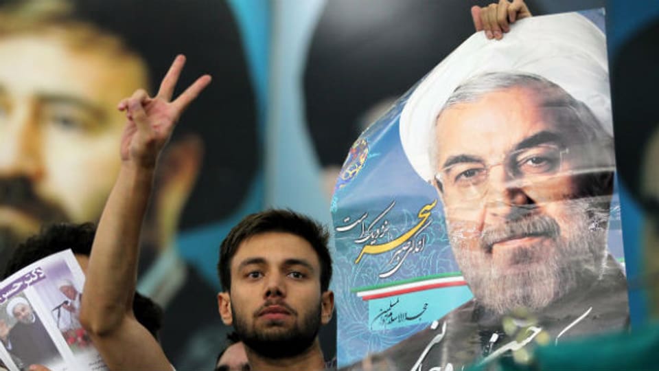 Ein junger Iraner mit einem Bild des neu gewählten Präsidenten Rohani.