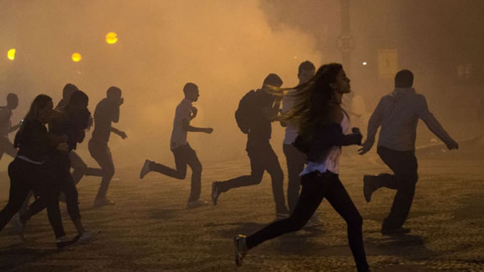 Die Demonstranten aus den Wolken von Tränengas während Anti-Regierungs-Proteste in Rio de Janeiro, Brasilien, Donnerstag, 20. Juni 2013.