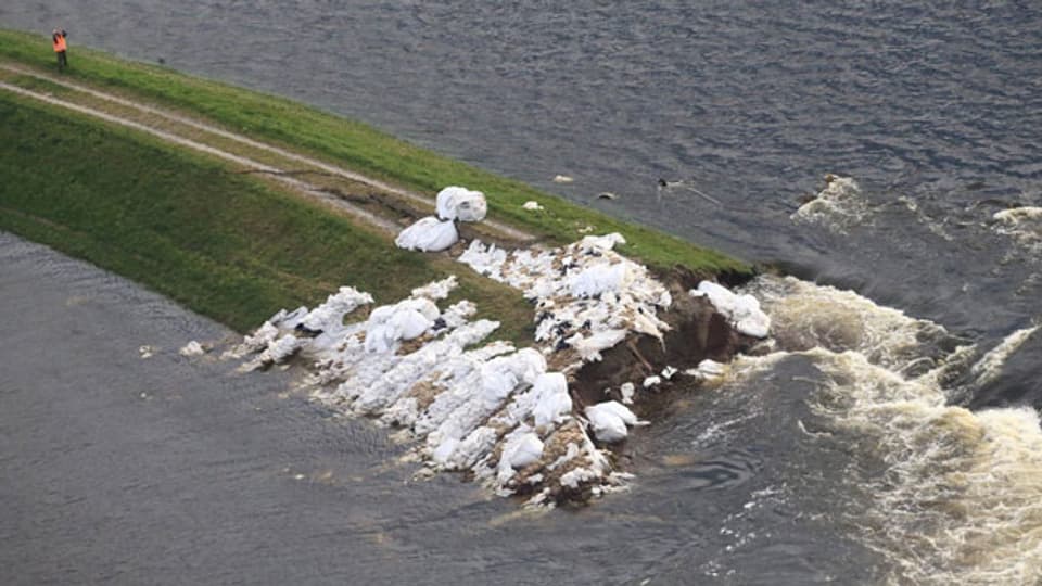 Das Wasser kam so schnell, die Leute konnten kaum etwas mitnehmen. Bild:  Flusswasser strömt über einen gebrochenen Deich in der Elbe in der Nähe von Fischbeck, Deutschland, am 15. Juni 2013.
