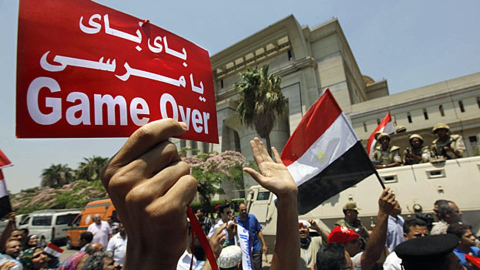 Ägypter feiern vor dem Sitz der Verfassungsgerichts in Kairo die Vereidigung von Adli Mansur. Auf dem Transparent steht: «Bye bye Mursi».