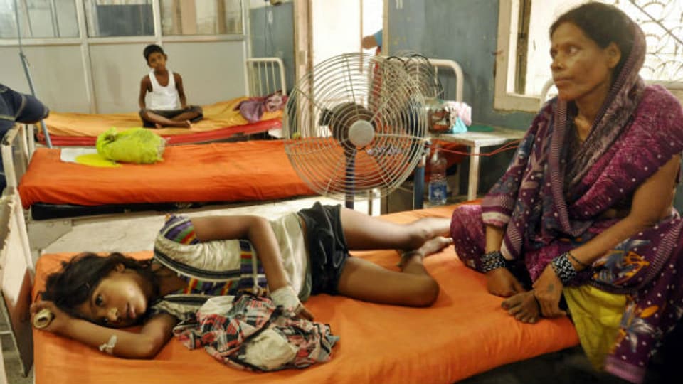Eine Frau kümmert sich um ein krankes Mädchen im Spital von Patna.