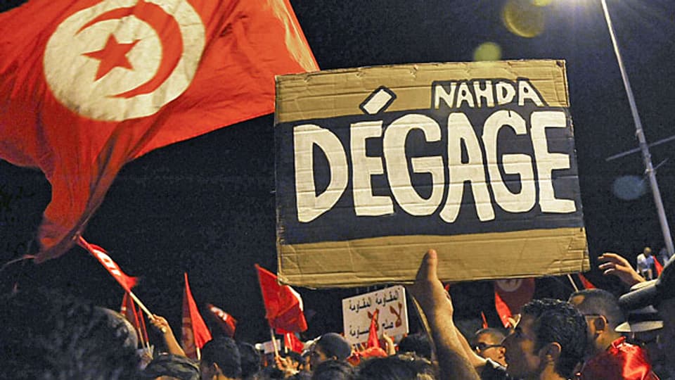 In der Nacht von Dienstag auf Mittwoch waren Zehntausende auf den Strassen von Tunis. Auf dem Protestplakat steht: «Ennahda zieh dich zurück!».