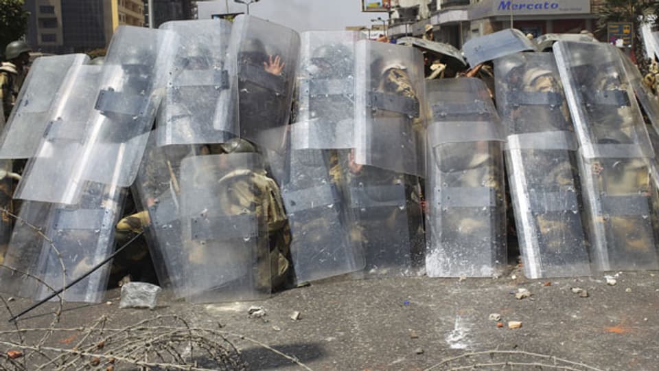 Polizei und Armee Soldaten schützen sich mit Schilden gegen Mitglieder der Muslimbruderschaft und Anhänger des gestürzten ägyptischen Präsidenten Mursi, die bei Zusammenstössen in Kairo am 14. August 2013 mit Steinen werfen.
