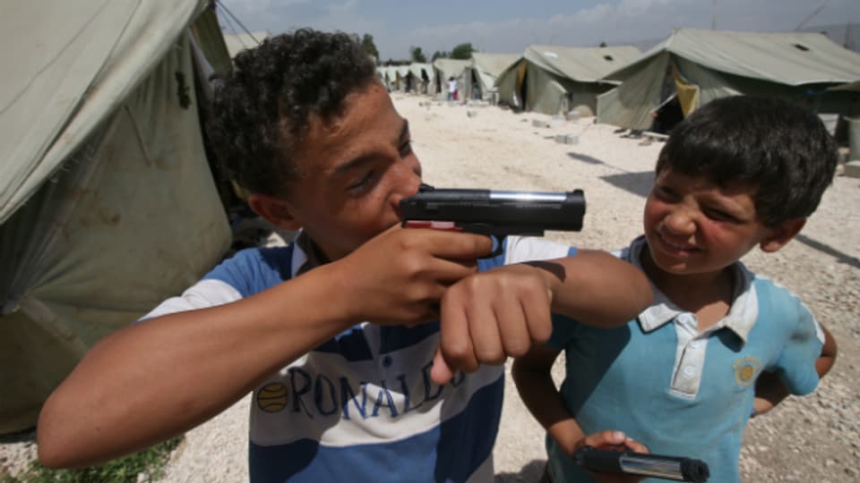 Syrische Kinder spielen in einem Flüchtlingslager in Libanon mit Spielzeugpistolen.