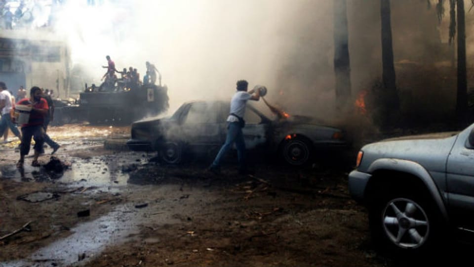 Tripoli: Männer versuchen die Brände nach dem Anschlag zu löschen.