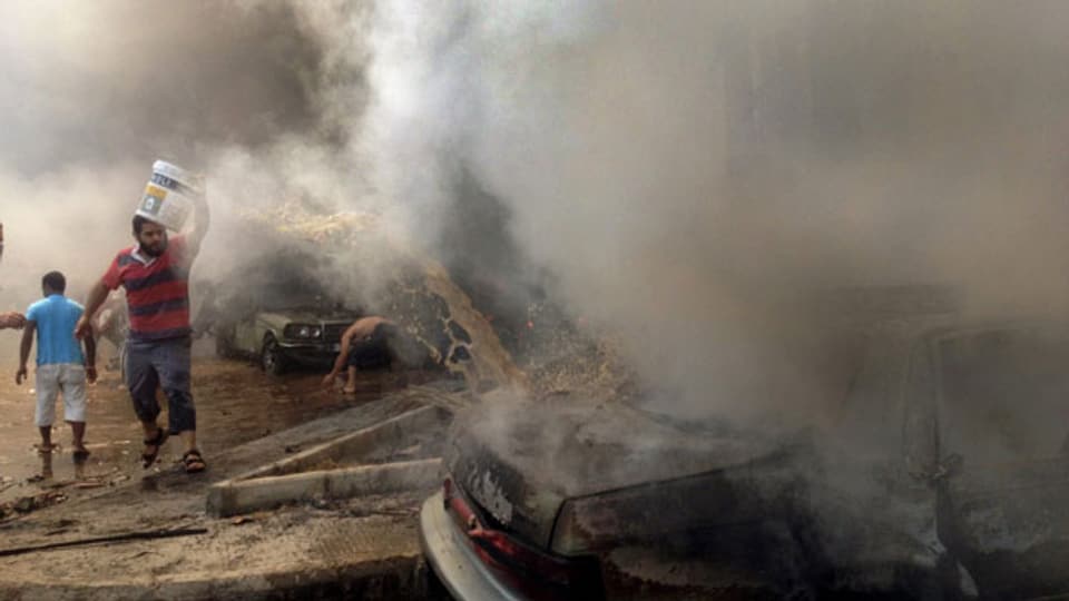 Rauch quillt aus einem brennenden Auto nach einer schweren Explosion in der nördlichen Stadt Tripoli, Libanon, am 23. August 2013. Mindestens 29 Menschen wurden getötet.