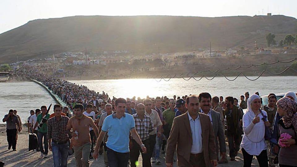 Tausende syrische Flüchtlinge überqueren am 15. August ein Brücke über den Tigris - und befinden sich damit in Irak.