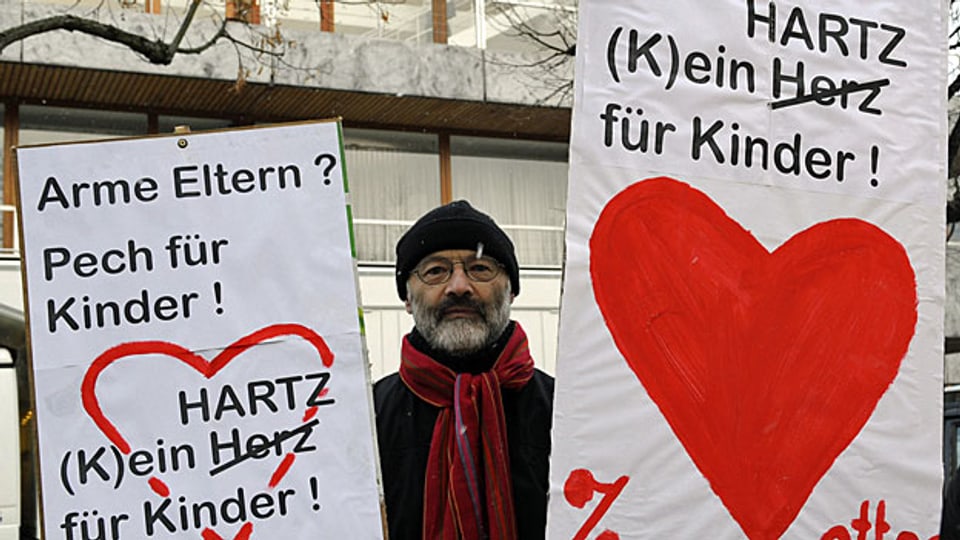 Ein Mann protestiert am 9. Februar 2010 vor dem Bundesverfassungsgericht in Karlsruhe - vor der Urteilsverkündung zu den Hartz IV-Regelsätzen für Kinder.