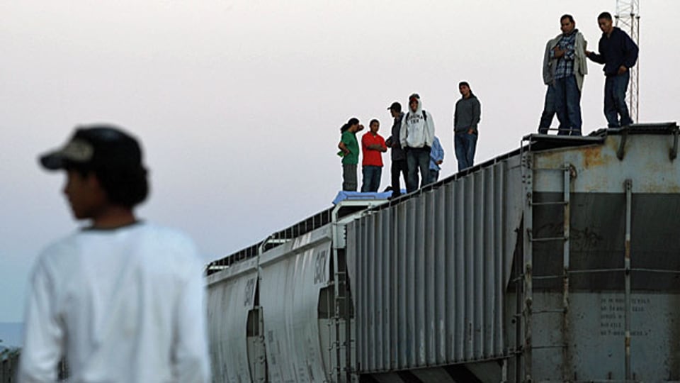 MigrantInnen aus Zentralamerika versuchen, auf einem Güterzug Mexiko zu durchqueren. Die Kosten für die Reise sind der Mafia zu entrichten.