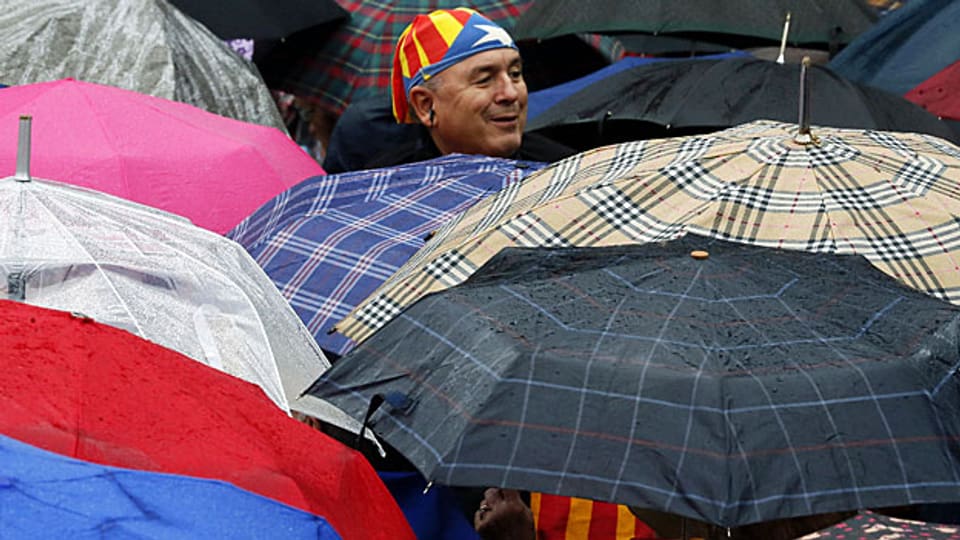 Ein Mann schützt sich am Nationalfeiertag mit der katalanischen Flagge.
