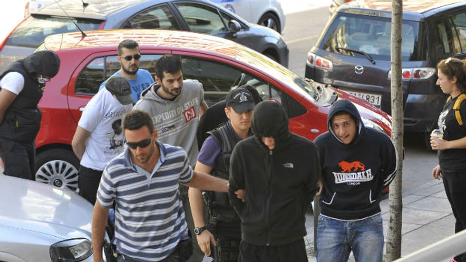 Tatverdächtige werden nach dem Mord an einem Rapper in Griechenland abgeführt.