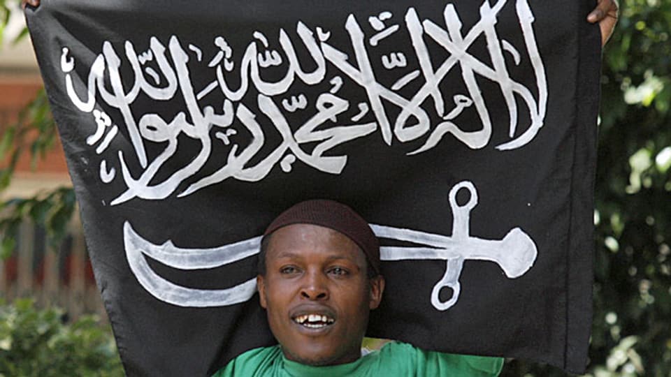 Ein junger Mann mit der Flagge der islamistischen al-Shabaab Milizen.