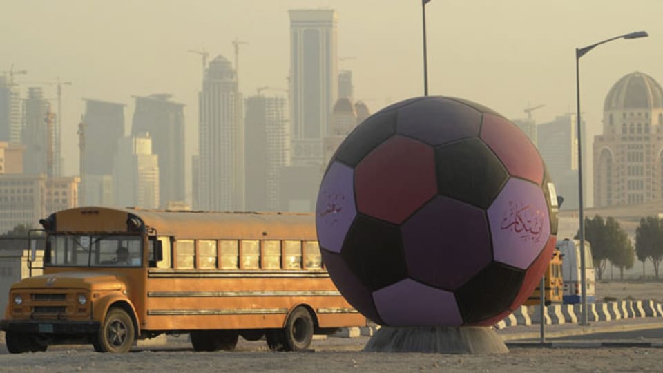 Ein überdimensionaler Fussball, der auf die Fussball-Weltmeisterschaft 2022 hinweist, in Doha im Emirat Katar. Die Gastarbeiter müssen unter menschenunwürdigen Zuständen arbeiten und werden ausgebeutet.