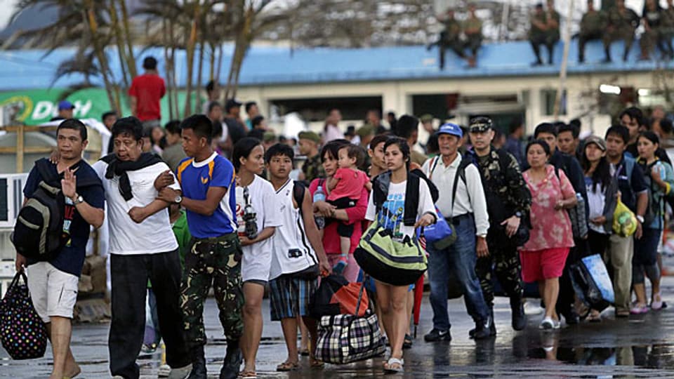 Überlebende auf dem Weg zu einem Militärflugzeug in Tacloban; sie werden ausgeflogen in die Hauptstadt Manila.