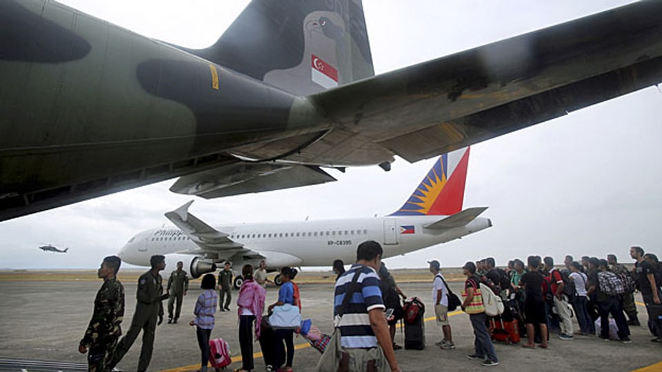 Überlebende der Wirbelsturm-Katastrophe warten darauf, mit einem Flugzeug auf  die Insel Cebu gebracht zu werden.