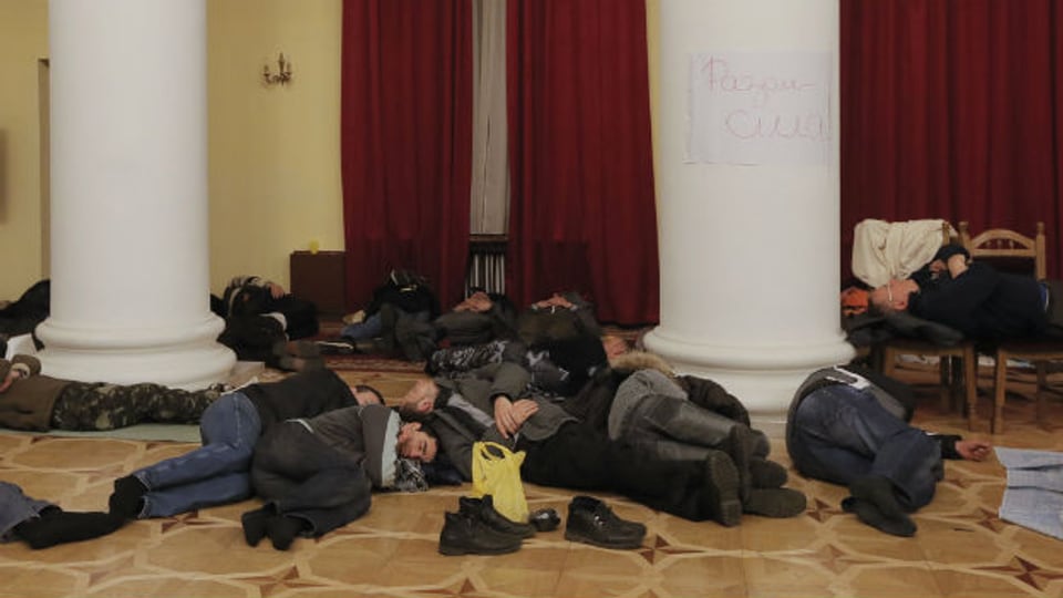 Ukrainische Demonstranten ruhen sich in einem besetzten Gebäude in Kiew aus.