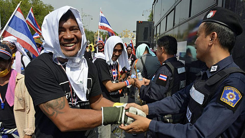 Händedruck zwischen Demonstranten, die gegen die Regierung protestieren und den Polizeikräften.