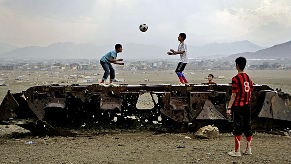 Den Preis für die Kriege zahlt immer die Zivilbevölkerung. Kinder in Afghanistan spielen auf einer alten russischen Panzerruine.