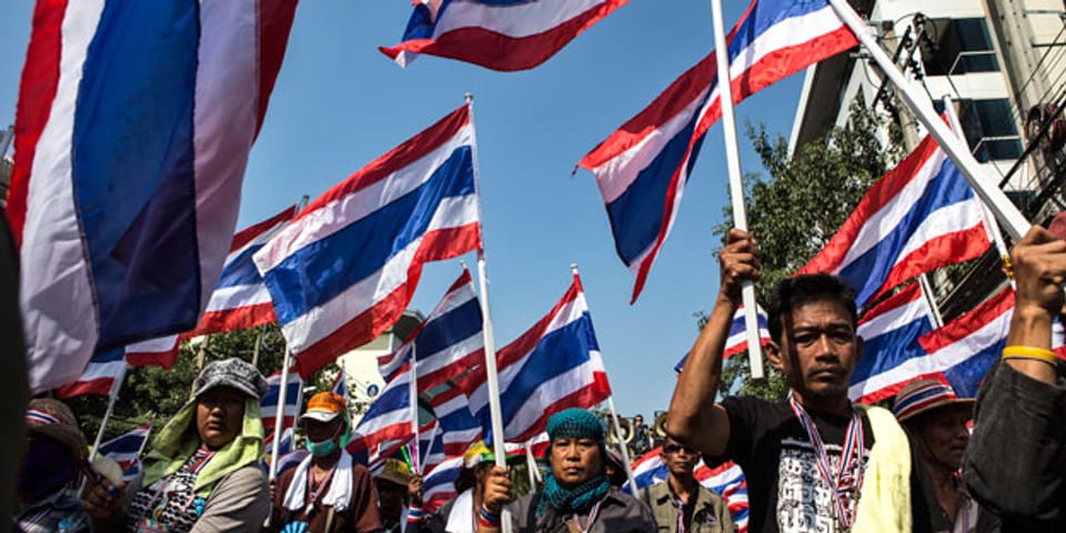 Anti-Regierungs-Demonstranten marschieren während einer Kundgebung am 17. Januar 2014 in Bangkok. Eine Bombe explodierte und mindestens 30 Demonstranten wurden verletzt.