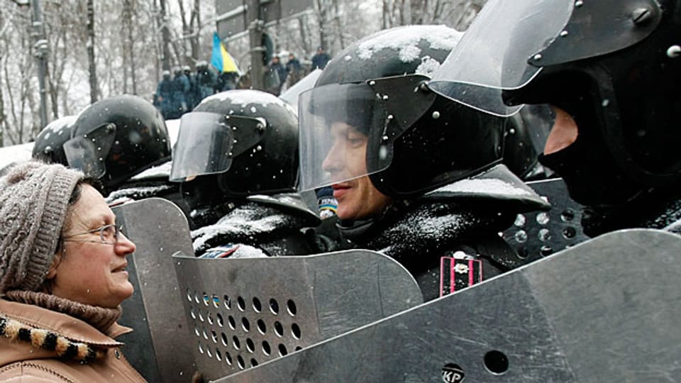 Eine Demonstrantin spricht in Kiew mit Polizeikräften. In den letzten Stunden gab es Gewaltausbrüche - auf beiden Seiten.