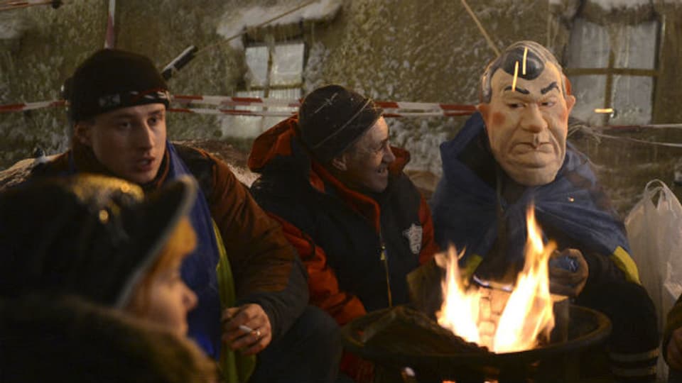 Wenigstens die Gummimaske mit dem Konterfei von Janukowitsch sorgt für Heiterkeit bei den Demonstranten.