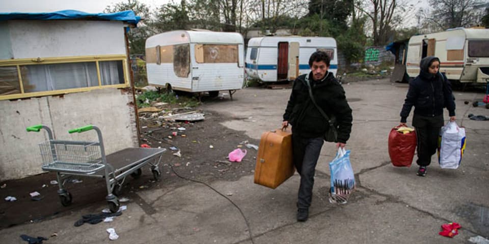 Ein Roma-Paar beim Verlassen eines nicht autorisierten Roma-Lagers in Saint-Ouen bei Paris, welches am 27. November 2013 von der französischen Polizei geräumt wurde. Symbolbild.
