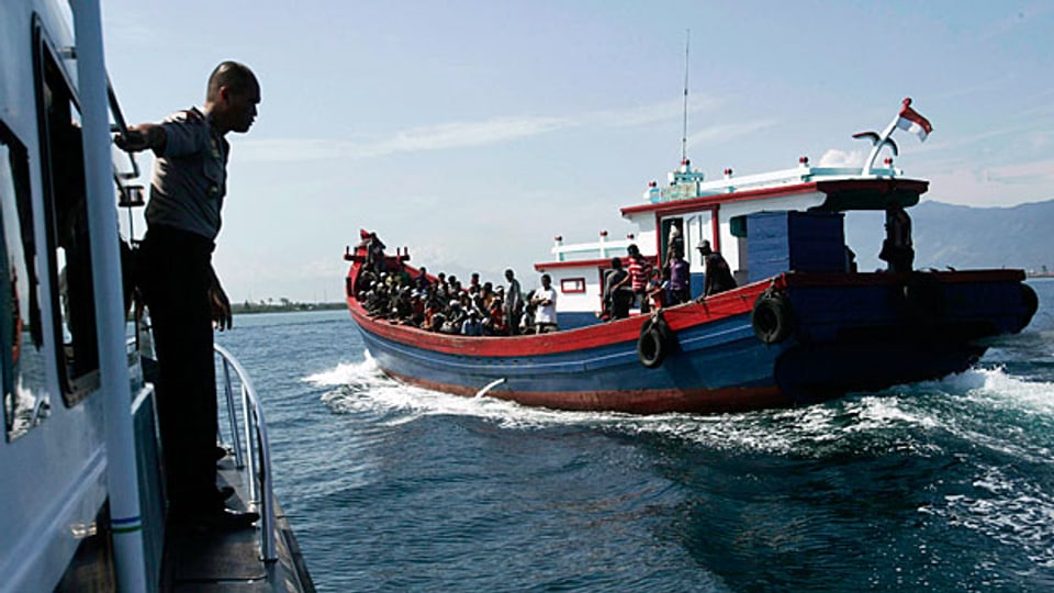 Indonesische Polizeikräfte bei einem Boot mit Flüchtlingen aus Burma; diese hoffen, die australische Küste zu erreichen.