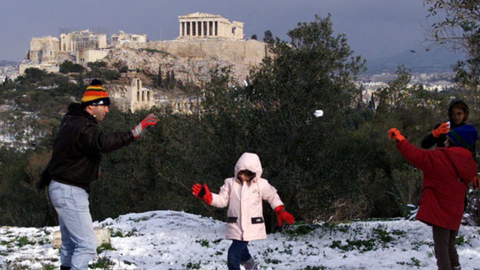 Weisse Woche: Antrieb für den Tourismus oder verlorene Unterrichtswoche? Bild: Eine Familie geniesst den Schnee vor der Akropolis.
