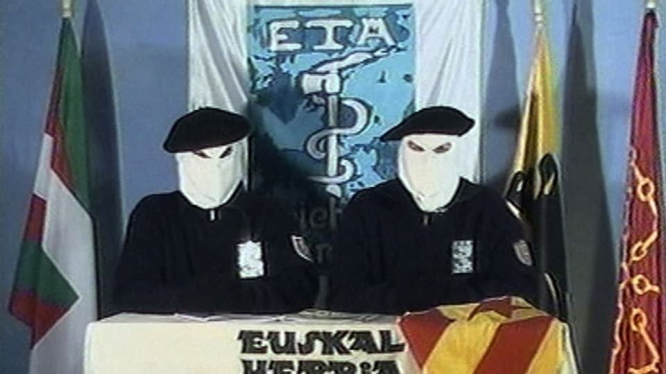 Zwei Mitglieder in Kapuzen der baskischen Untergrundorganisation ETA verlesen eine Erklärung für einen Waffenstillstand. Archivbild.