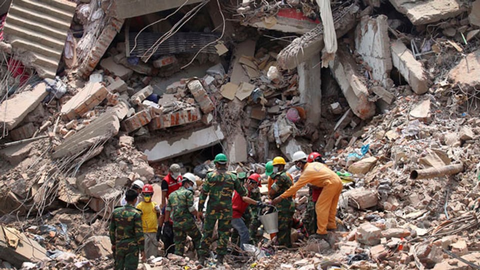 Arbeiter versuchen, zwei Leichen aus den Trümmern des eingestürzten Fabrikgebäudes zu bergen. Beim Zusammensturz am 24. April 2013 verloren 1129 Menschen ihr Leben.