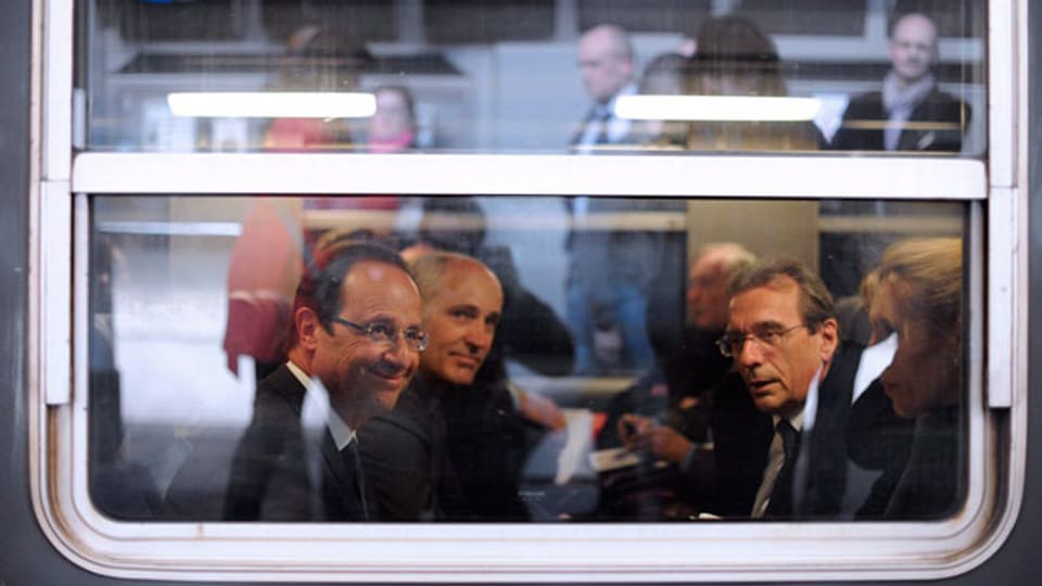François Hollande (links) im Zug in Paris mit seinem Berater Thierry Repentin (zweiter von links) dem Strassburger Bürgermeister Roland Ries (rechts) am 22. April 2012.