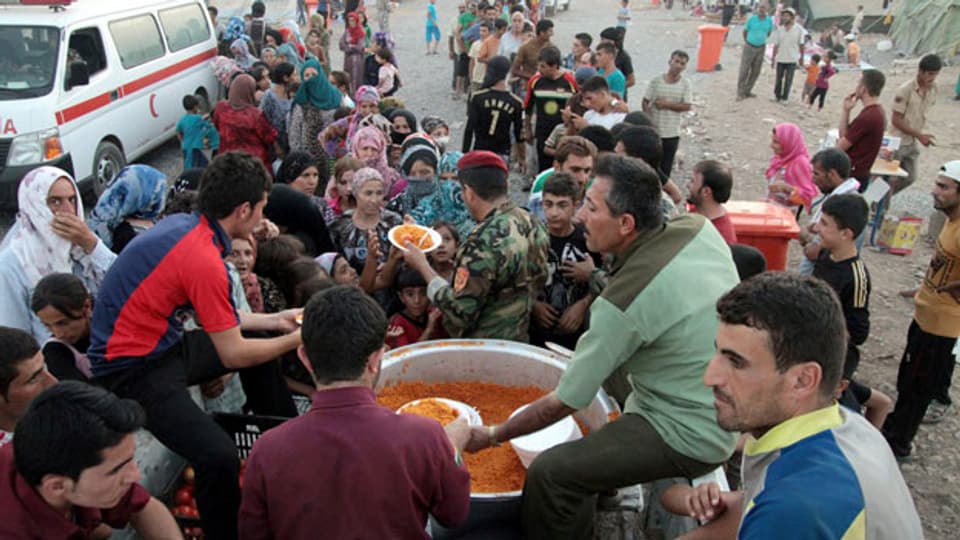 Soldaten bei der Verteilung von Lebensmitteln im Flüchtlingslager von Kawergost in Erbil, Nordirak am 22. August 2013.