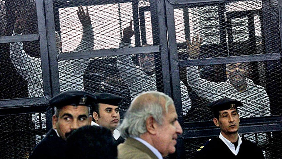 Ein Anwalt von verhafteten Muslimbrüdern an einem Gericht in Kairo, im Hintergrund die Verhafteten in Käfigen, Dezember 2013.