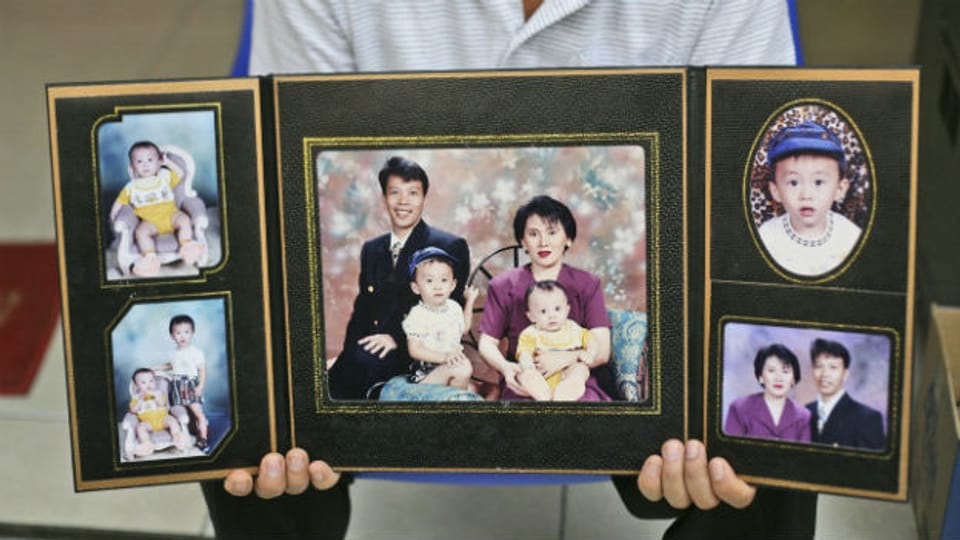 Angehöriger zeigt Bild von Opfer des Flugs MH370