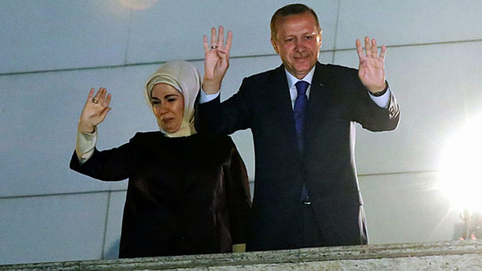 Der türkische Premier und seine Frau winken ihren AnhängerInnen und Anhängern zu, nachdem die AKP die Gemeindewahlen gewonnen hat.