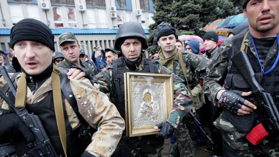 Prorussische Separatisten in Luhansk tragen eine Ikone vor dem besetzten Regierungsgebäude.