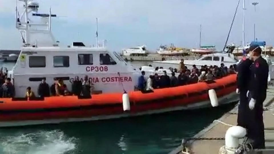 Boot der italienischen Küstenwache mit Flüchtlingen im Hafen von Pozzallo.