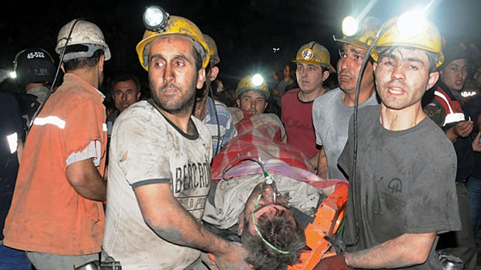Grubenarbeiter transportieren einen verletzten Kumpel aus der Kohlenmine von Soma.