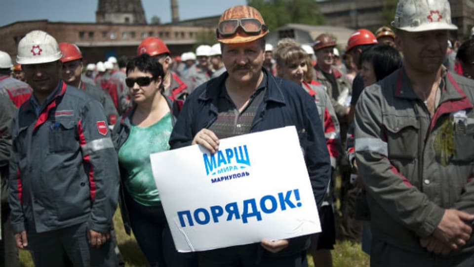 Angestellte von Achmetovs Stahlkonzern in Mariupol. Auf dem Plakat: «Marschiert. Diszipliniert.»