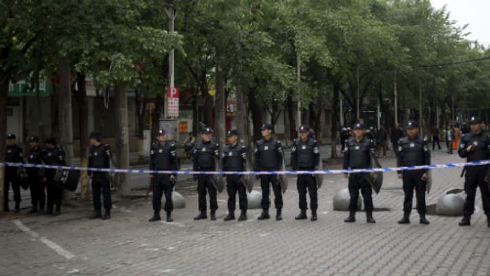 Polizisten bewachen den Marktplatz in Urumqi, wo gestern Sprengsätze explodierten.