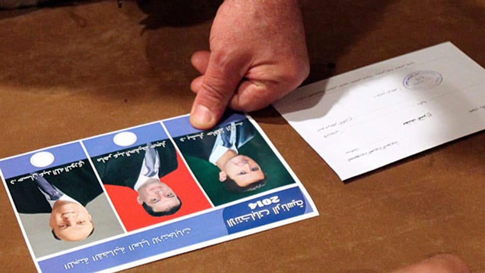 Ein Wähler markiert die Wahlkarte mit seinem Blut.