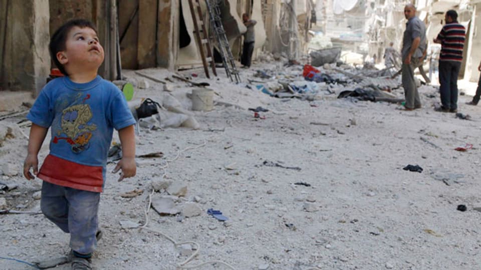 Das Morden geht weiter, trotz der Verhandlungen in Genf, trotz dem Abkommen zur Vernichtung chemischer Waffen. Ein kleiner Junge im zerstörten Aleppo am 14. Juni 2014.