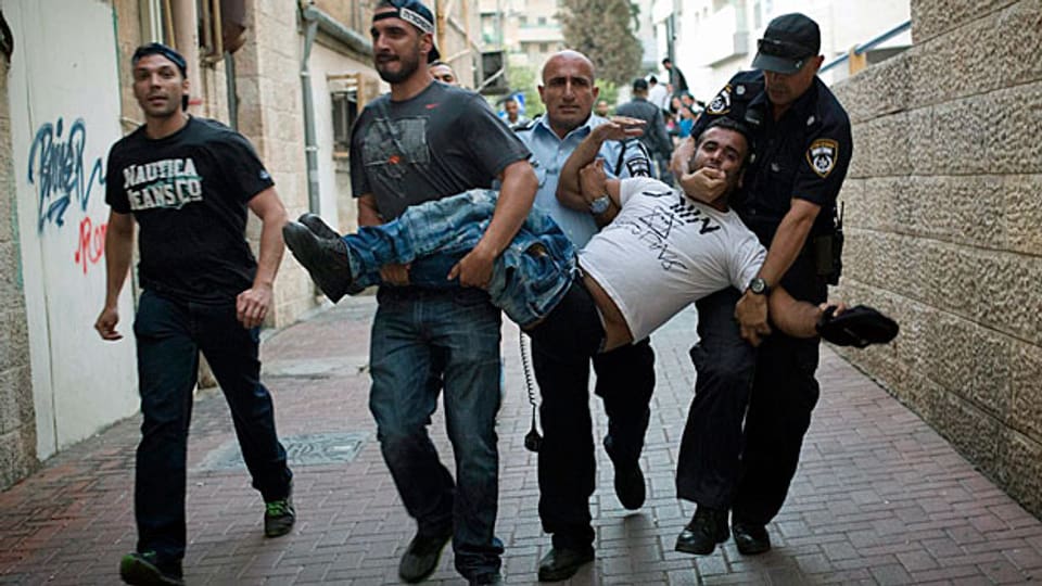 In Jerusalem gehen israelische Polizisten gegen rechtsextreme jüdische Siedler vor, die versucht haben, israelische Araber in ihre Fahrzeuge zu zerren.