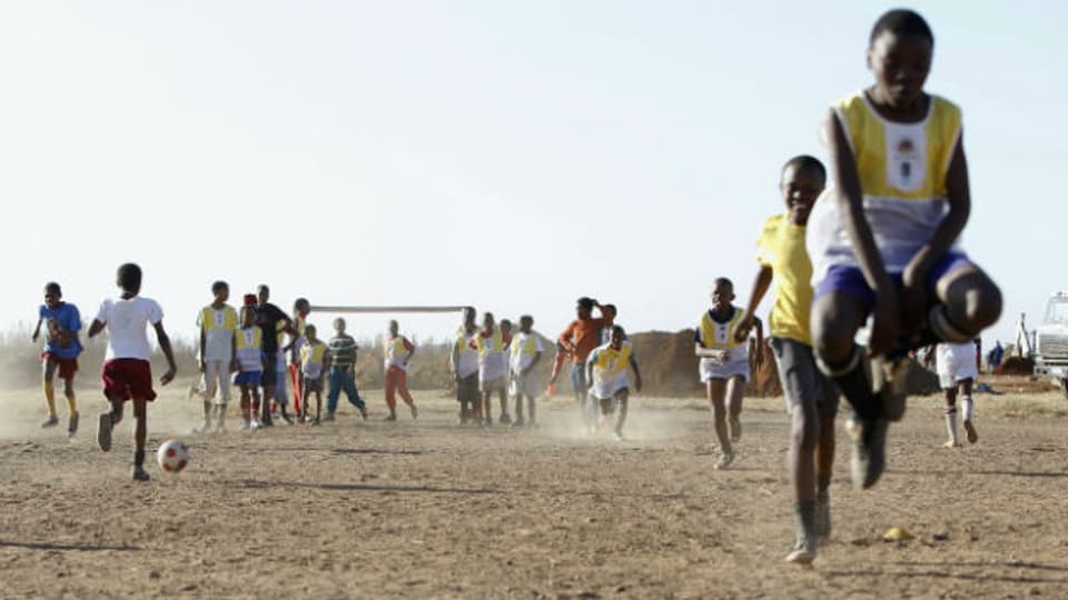 Jugendliche und Kinder spielen Fussball in Südafrika.