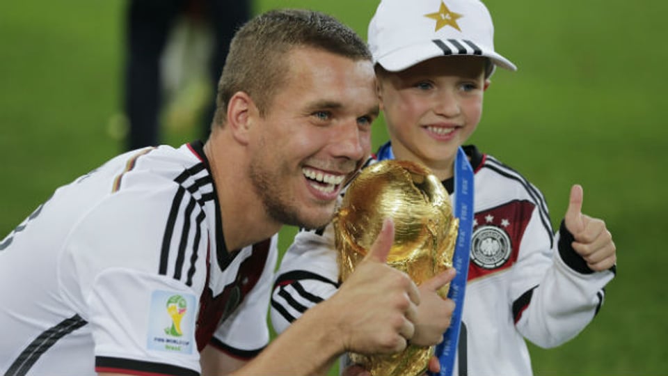  Lukas Podolski und sein Sohn mit dem Fussball-WM-Pokal.