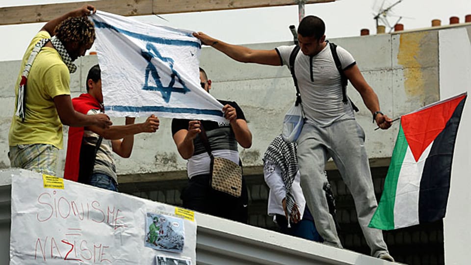 Pro-palästinensische Demonstranten in Paris setzen eine israelische Flagge in Brand.