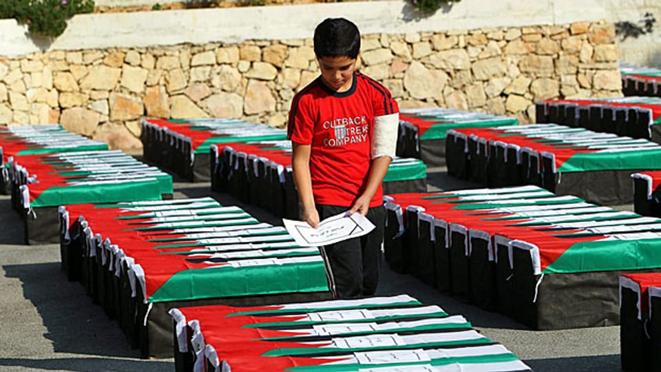 Ein junger Palästinenser bereitet symbolische Särge vor - für eine Protestkundgebung gegen das Vorgehen Israels in Gaza.