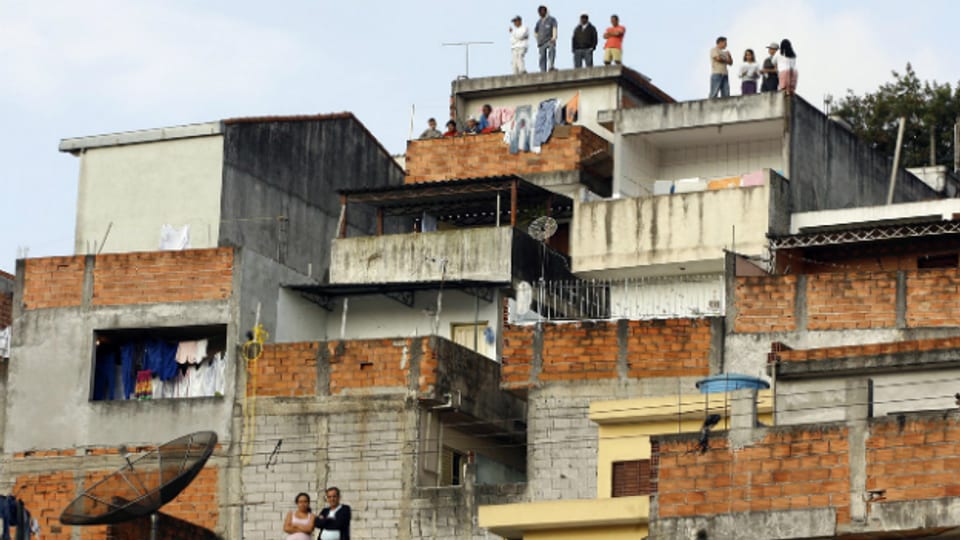 Menschen stehen auf den Dächern ihrer Häuser in Sao Paolo (Archivbild).